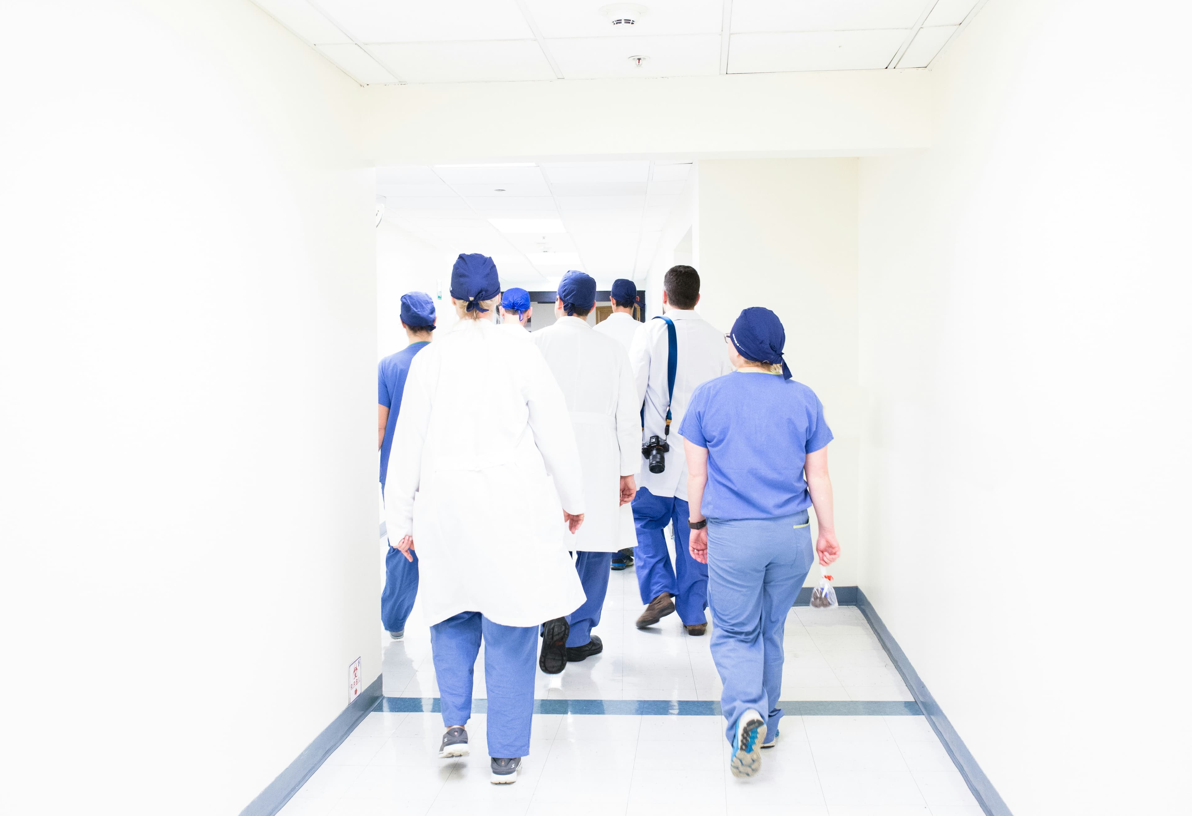 Healthcare team moving through a hospital hallway.